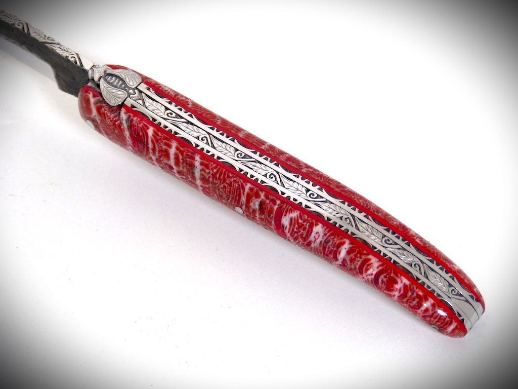Laguiole Corail fossile rouge, Lame "Brut de Forge", ciselé par David DAUVILLAIRE